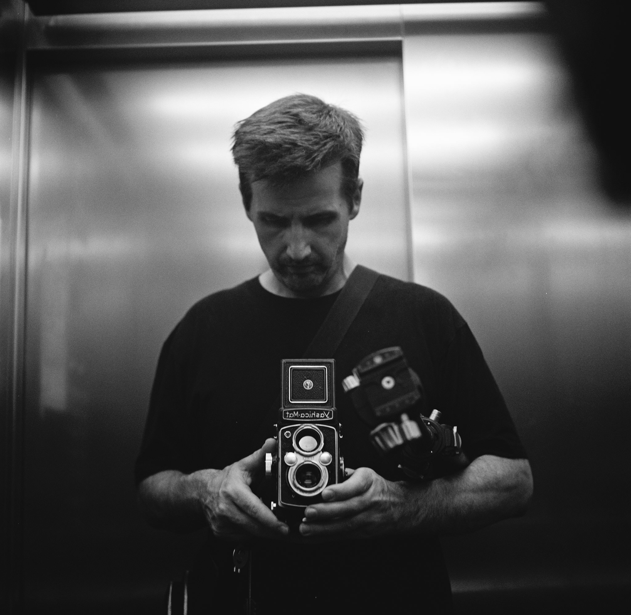 Black-and-white self-portrait of Dan Pearce holding a Yashica camera